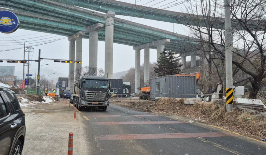 ▲용인특례시 수지구 고기동의 노인복지주택 공사현장에 지난 3월 한시적으로 허용됐던 토사 반출 당시 고기초 앞 도로를 지나는 공사차량 (용인특례시)