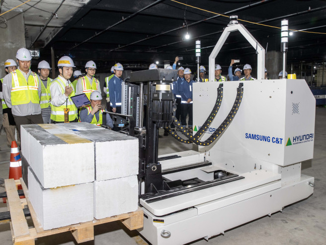 ▲현대건설과 삼성물산이 공동 개발한 '스마트 자재 운반 로봇'이 현장에서 자재를 싣고 자율주행 이동하고 있다. 