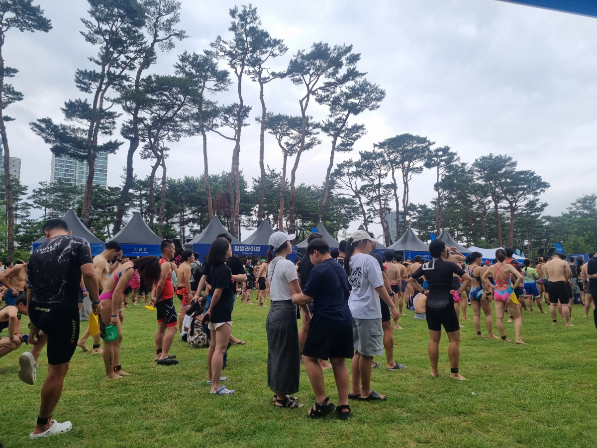 ▲6일 서울 송파구 석촌호수 및 롯데월드타워에서 '2025 롯데 아쿠아슬론’ 대회가 열렸다. 대회 시작 전인 오전 6시 30분께 참가자들이 잔디밭에 모여 몸을 풀고 있다. (유하영 기자 haha@)
