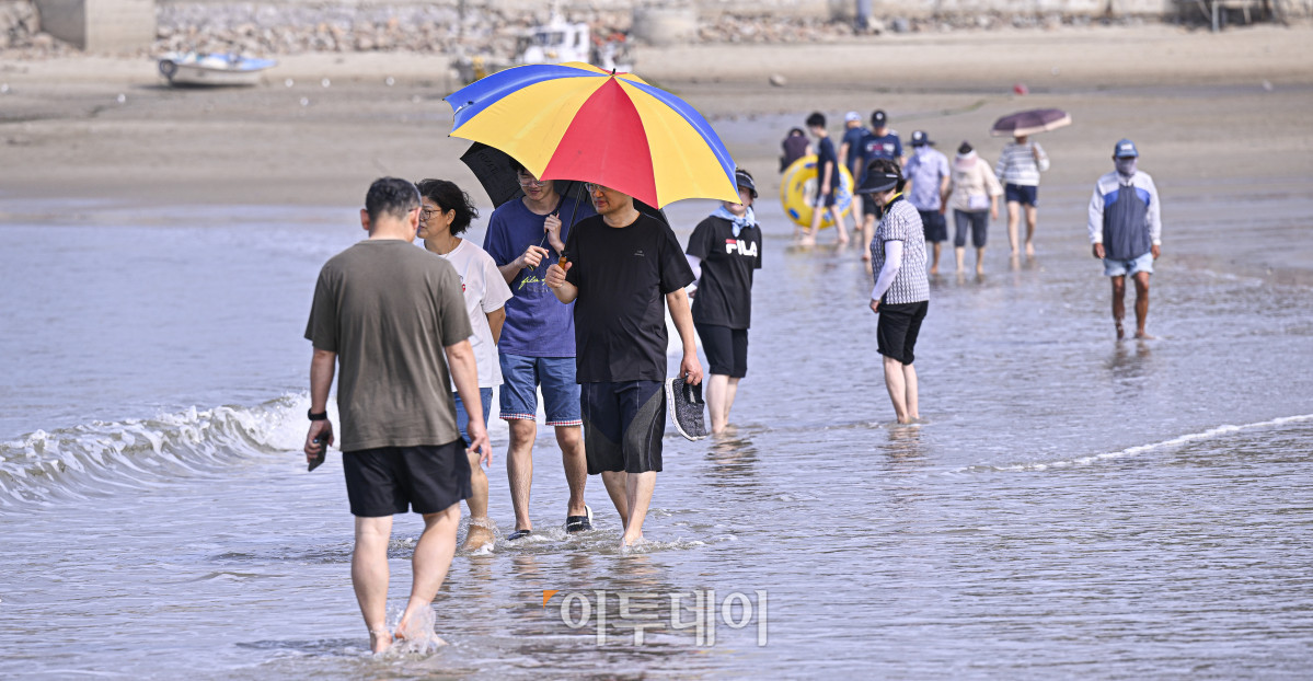 ▲전국에 폭염특보가 발효 중인 6일 인천 중구 을왕리해수욕장에서 시민들이 해안가를 걸으며 더위를 식히고 있다. 조현호 기자 hyunho@