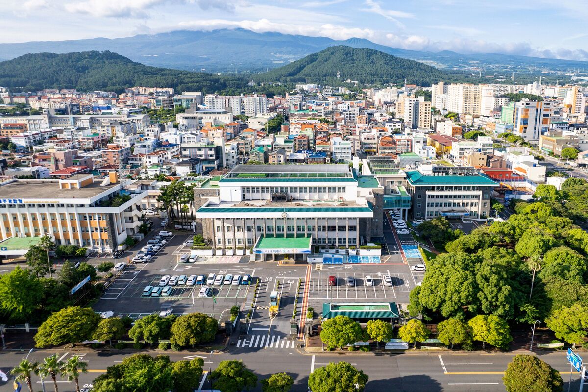 ▲제주 지역 도심 전경이 맑은 날씨 속에 보이는 가운데, 넓은 주차장을 포함한 상업시설 주변에 착한가격업소가 선정·운영되고 있다. (사진제공 = 제주도)