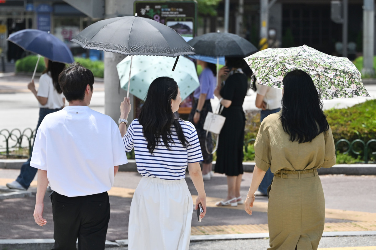 ▲광주지역에 폭염특보가 8일째 이어진 4일 오후 광주 북구청 사거리에서 시민들이 양산을 쓴 채 걷고 있다. (뉴시스)