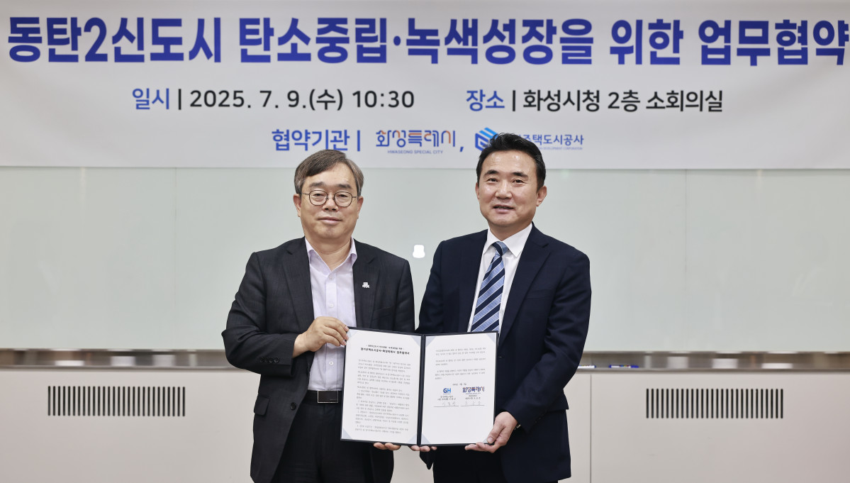 ▲이종선 경기주택도시공사 사장 직무대행과 조승문 화성특례시 부시장이 9일 화성시청에서 열린 동탄2신도시 탄소중립·녹색성장 업무협약식에서 협약서를 들고 있다. (GH)
