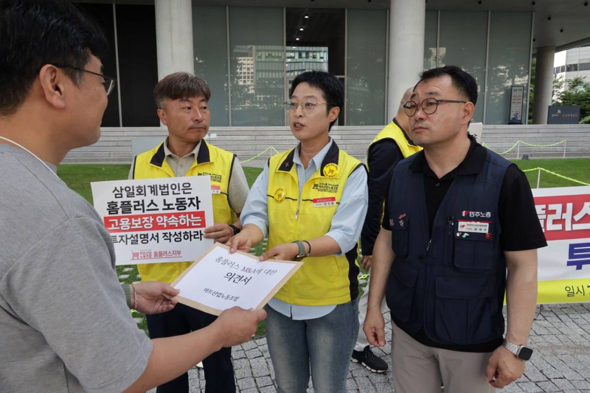 ▲9일 오전 서울 용산구 삼일회계법인 앞에서 열린 기자회견 이후 안수용 마트산업노동조합 홈플러스지부장(가운데)이 삼일회계법인 측에 '고용 보장과 점포 폐점 최소화'를 골자로 하는 공식 의견서를 전달하고 있다. (사진제공=마트산업노동조합 홈플러스지부)