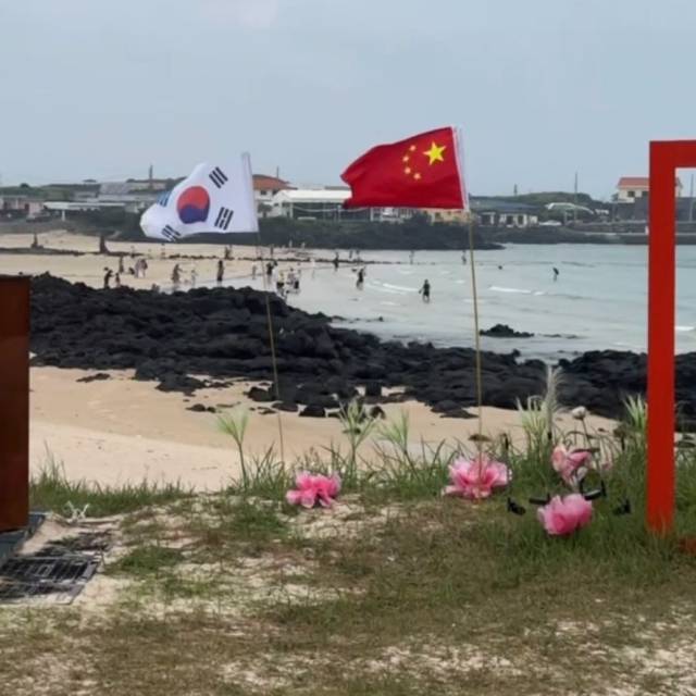 ▲ 제주도 우도 한 해변에 중국 국기가 우리 태극기와 나란히 꽂혀 있는 모습이다.  (사진제공=스레드 캡처)