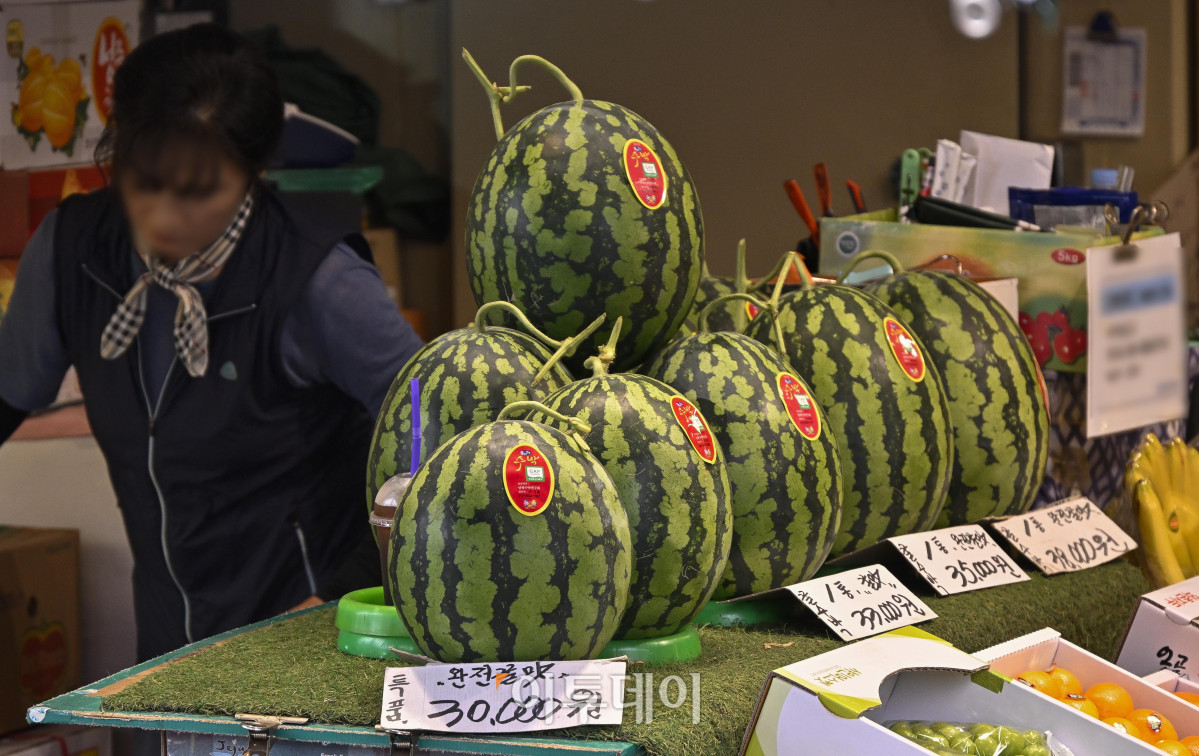 ▲무더위에 물량 부족 및 수요 증가로 수박 한 통 평균 소매 가격이 상승하면서 3만원을 넘어섰다. 15일 한국농수산식품유통공사(aT) 집계에 따르면 전날 수박(상품) 한 통 평균 소매 가격은 전통시장에서 3만327원으로 3만원을 돌파했다. 이날 서울 시내 한 전통시장에 수박이 진열되어 있다. 조현호 기자 hyunho@