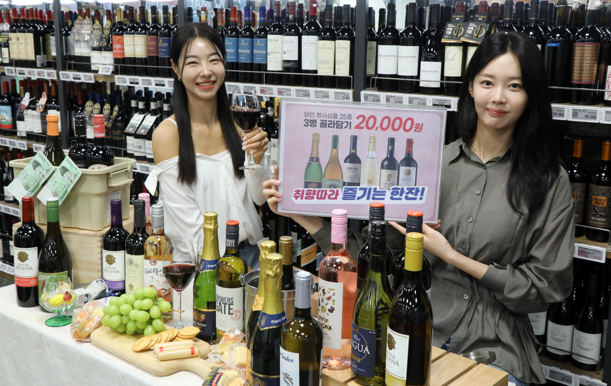 ▲ 이마트 용산점에서 모델들이 31일까지 업계 최초로 선보이는 '와인 골라담기' 행사를 소개하고 있다.  (사진제공=이마트)