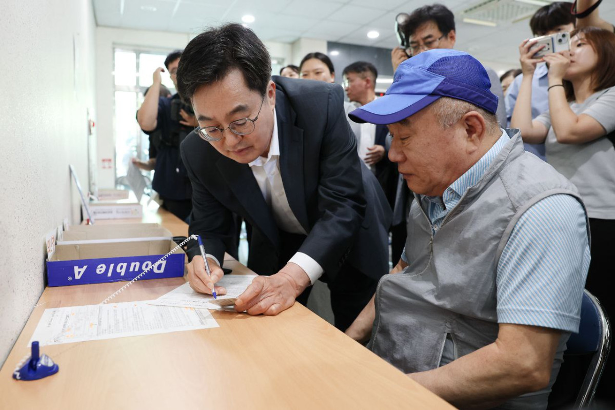 ▲김동연 경기도지사가 21일 수원 원천동 행정복지센터에서 한 어르신의 민생회복 소비쿠폰 신청서 작성을 돕고 있다. (경기도)