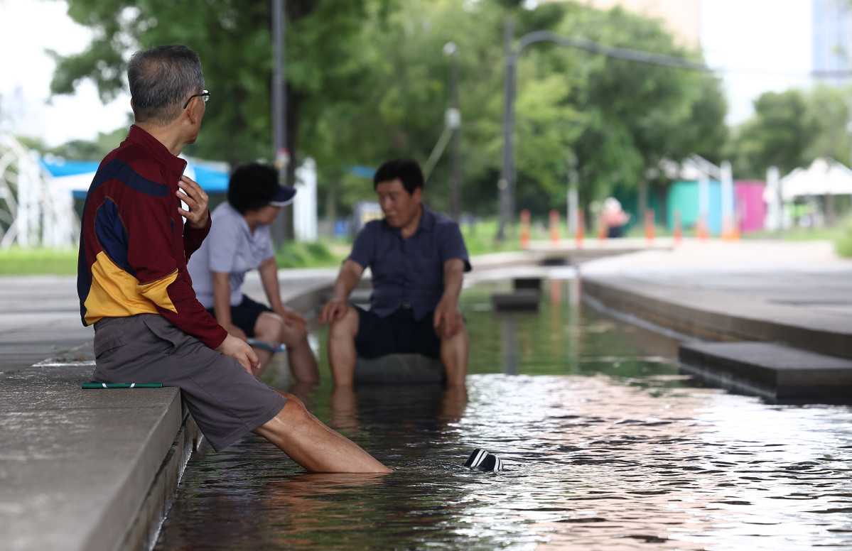 ▲21일 서울 영등포구 여의도한강공원에서 시민들이 물에 발을 담그고 있다. (연합뉴스)
