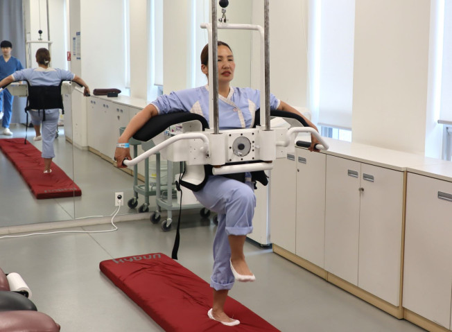 ▲자생한방병원 의료진이 나랑체첵 씨의 경추와 팔꿈치, 발등에 동작침을 놓은 뒤 스스로 걷도록 유도하는 동작침법을 시행하고 있다. (사진제공=자생한방병원)