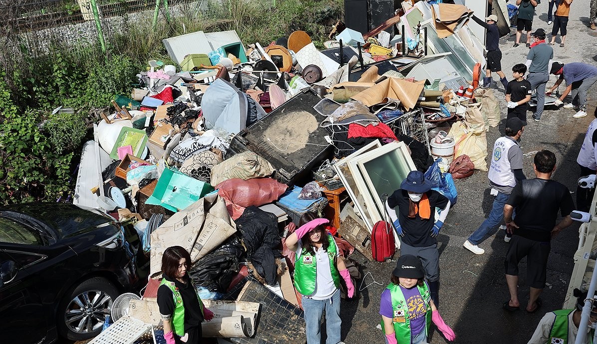 ▲광주 북구 신안교 인근 도로에서 자원봉사자들이 주택과 상가에서 나온 폐기물을 옮겨 모으고 있다. (연합뉴스)