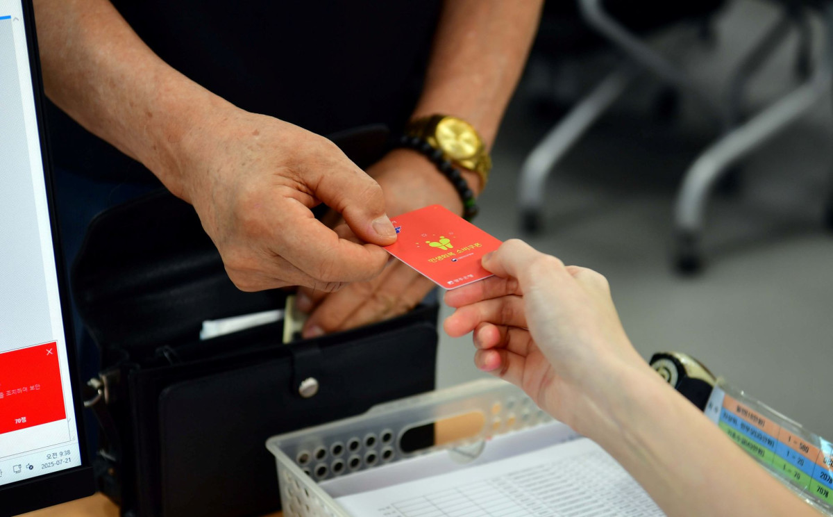 ▲ 21일 오전 광주 서구 상무1동행정복지센터에서 한 주민이 민생회복 소비쿠폰 카드를 발급받고 있다. (뉴시스)