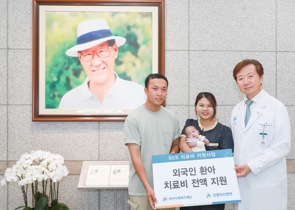 ▲유창식 병원장과 환아의 가족이 고(故) 정주영 아산사회복지재단 설립자의 사진 앞에서 기념촬영을 하고 있다. (강릉아산병원)