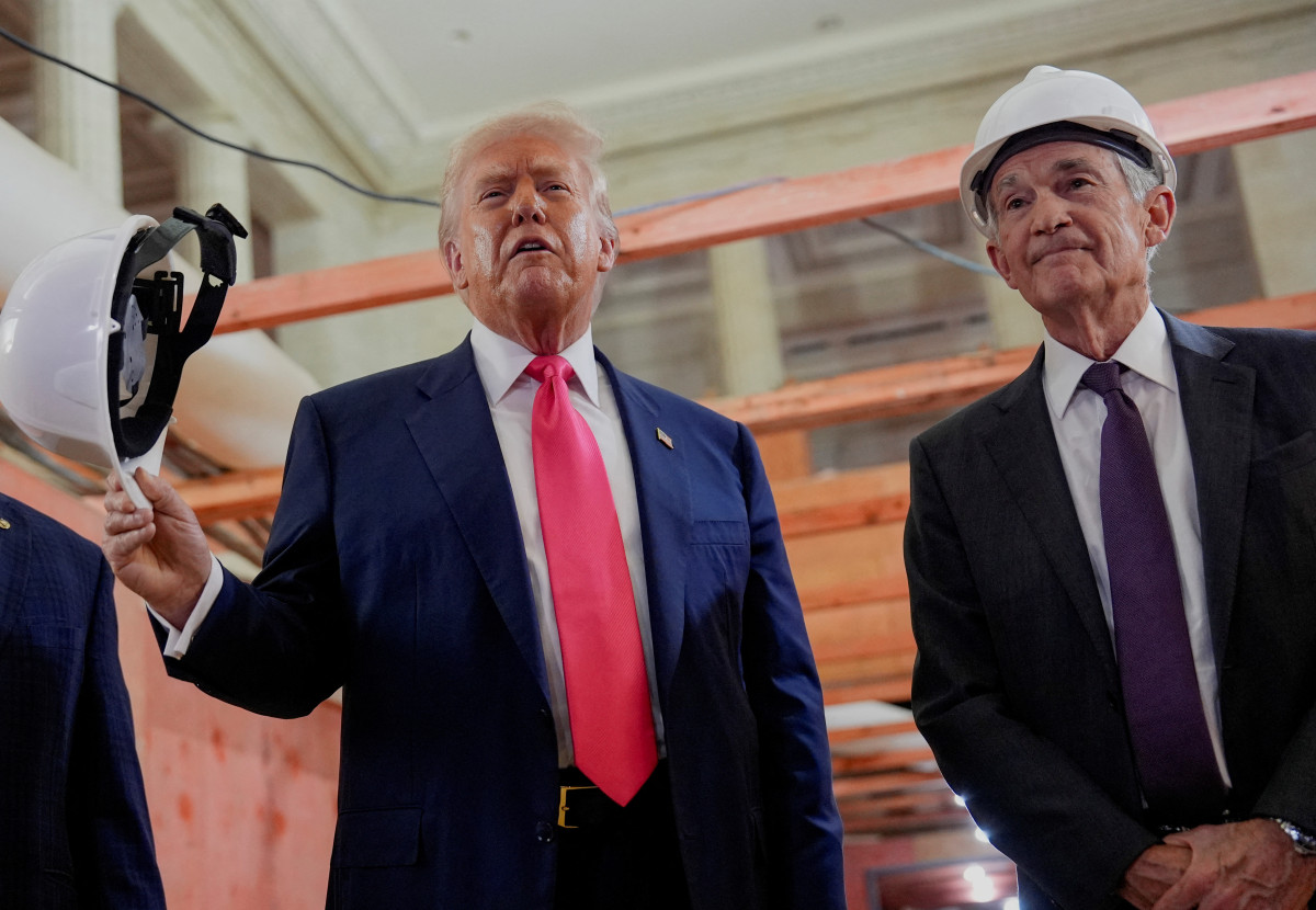 ▲워싱턴DC 연준 본부를 찾은 트럼프 대통령이 기자들의 질문에 답하고 있다. 제롬 파월(오른쪽) 연준 의장이 안전모를 쓴 채 트럼프 옆에서 손을 모으고 있다. (워싱턴DC=로이터연합)