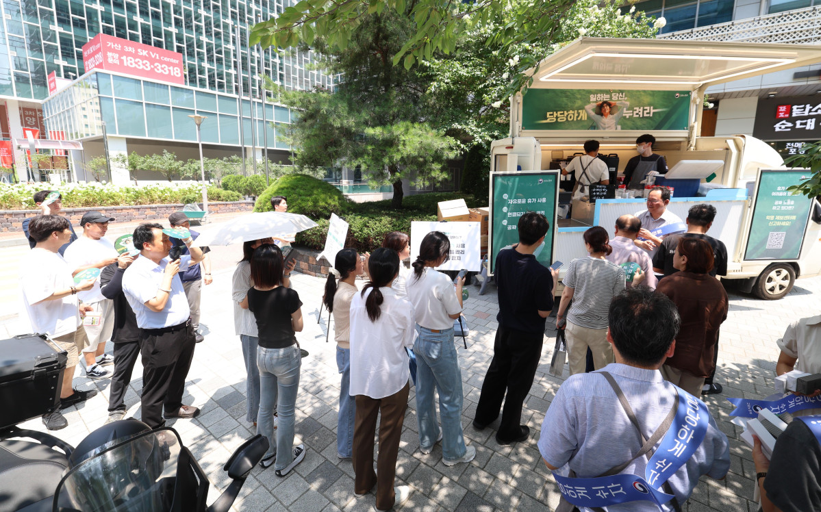 ▲28일 서울 금천구 가산디지털단지의 한 거리에서 직장인들이 고용노동부에서 제공하는 무료 커피를 받아가고 있다. 이날 캠페인은 고용부가 ‘일하는 당신, 당당하게 누려라’란 주제로 하계 휴가철을 맞아 자유로운 휴가 사용 등의 메시지 전달을 위해 마련했다. 신태현 기자 holjjak@