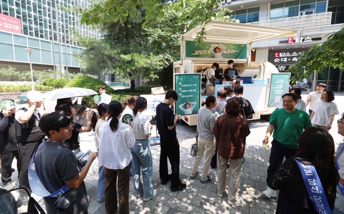 ▲28일 서울 금천구 가산디지털단지의 한 거리에서 직장인들이 고용노동부에서 제공하는 무료 커피를 받아가고 있다. 이날 캠페인은 고용부가 ‘일하는 당신, 당당하게 누려라’란 주제로 하계 휴가철을 맞아 자유로운 휴가 사용 등의 메시지 전달을 위해 마련했다. 신태현 기자 holjjak@