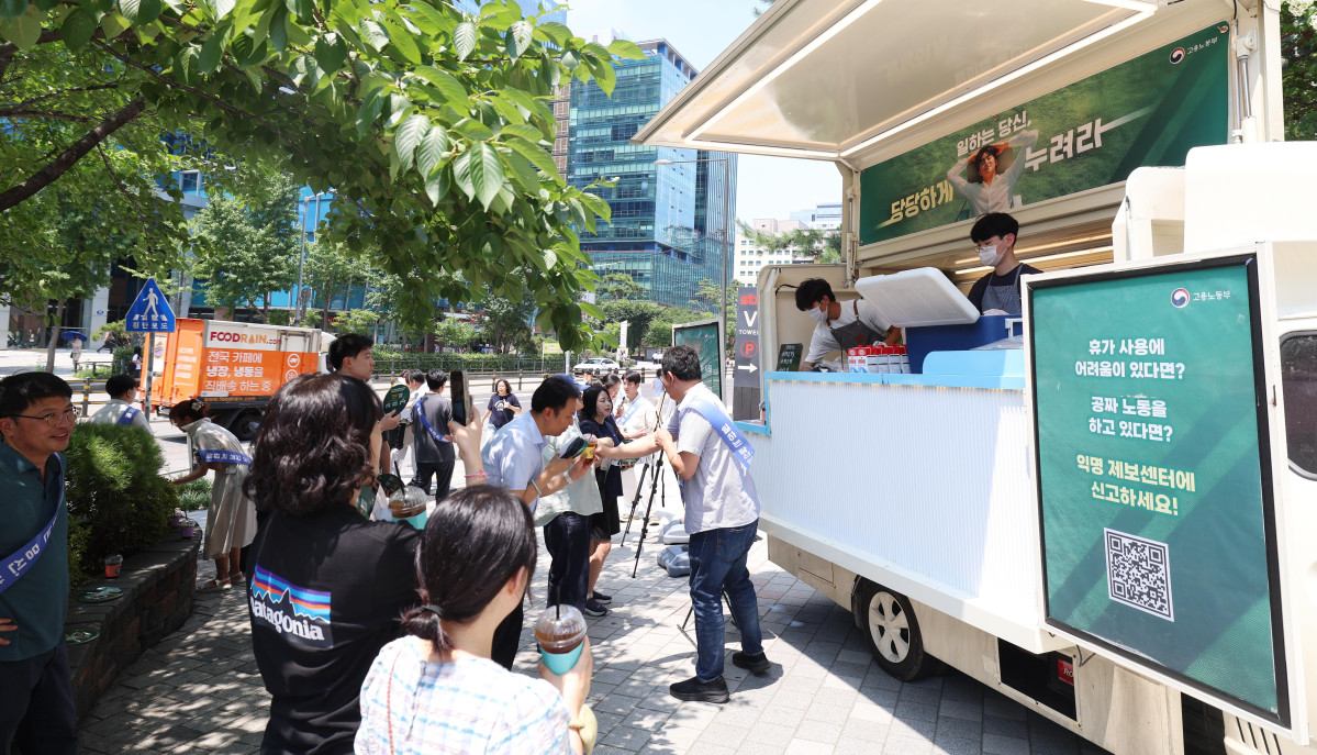 ▲28일 서울 금천구 가산디지털단지의 한 거리에서 직장인들이 고용노동부에서 제공하는 무료 커피를 받아가고 있다. 이날 캠페인은 고용부가 ‘일하는 당신, 당당하게 누려라’란 주제로 하계 휴가철을 맞아 자유로운 휴가 사용 등의 메시지 전달을 위해 마련했다. 신태현 기자 holjjak@