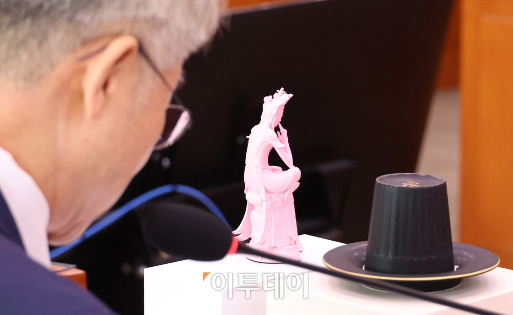 ▲민형배 더불어민주당 의원이 29일 서울 여의도 국회 문화체육관광위원회에서 열린 최휘영 문화체육관광부 장관 후보자 인사청문회에서 넷플릭스를 통해 공개된 애니메이션 '케이팝 데몬 헌터스'의 인기를 설명하며 국립중앙박물관에서 만든 문화상품 '반가사유상 미니어처'와 '갓잔'을 소개하고 있다. 고이란 기자 photoeran@