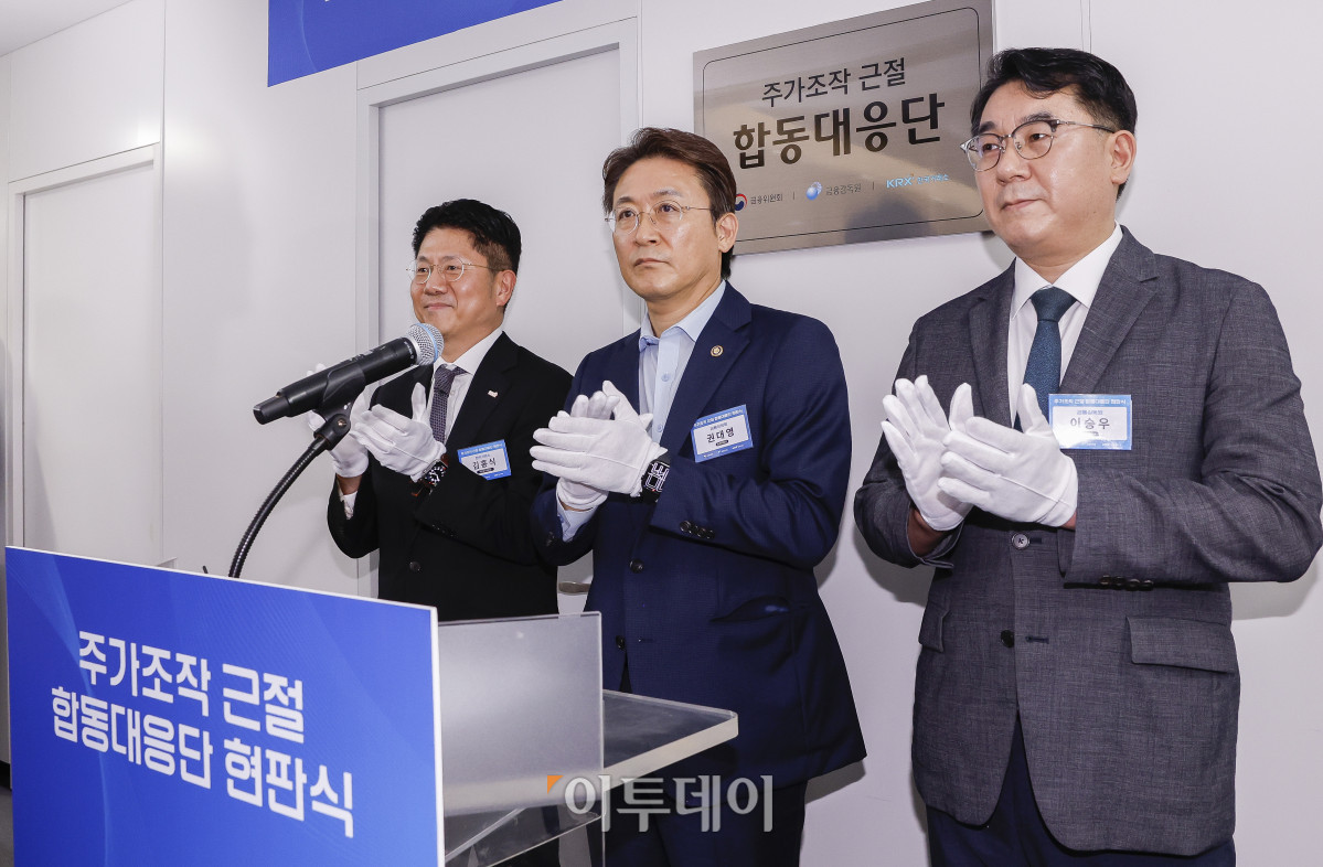 ▲권대영(가운데) 금융위원회 부위원장과 김홍식(왼쪽) 한국거래소 시장감시위원장, 이승우 금융감독원 부원장보 겸 합동대응단장이 30일 서울 영등포구 한국거래소에서 열린 주가조작 근절 합동대응단 현판식을 마친 후 박수를 치고 있다. 조현호 기자 hyunho@
