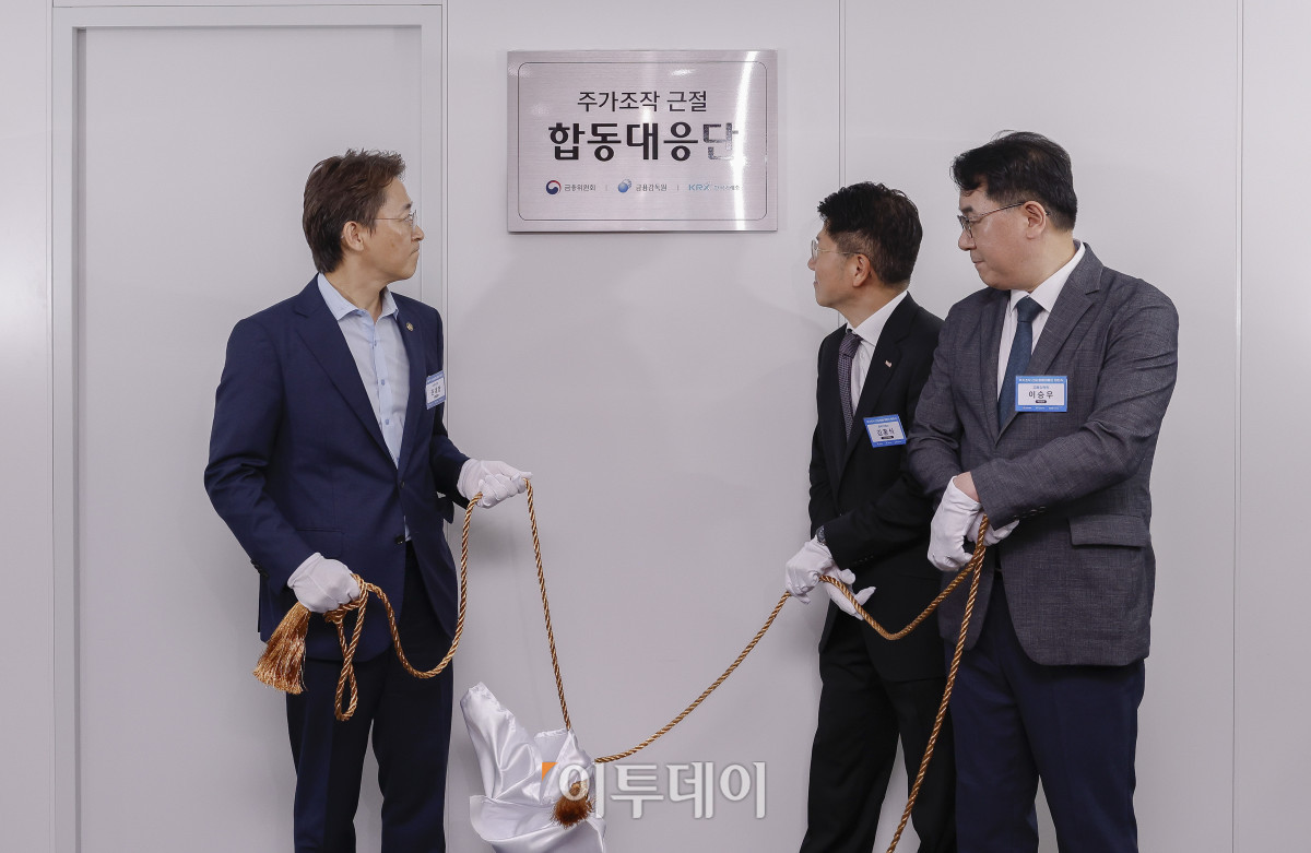 ▲권대영(왼쪽부터) 금융위원회 부위원장과 김홍식 한국거래소 시장감시위원장, 이승우 금융감독원 부원장보 겸 합동대응단장이 30일 서울 영등포구 한국거래소에서 열린 주가조작 근절 합동대응단 현판식에서 현판 제막을 하고 있다. 조현호 기자 hyunho@