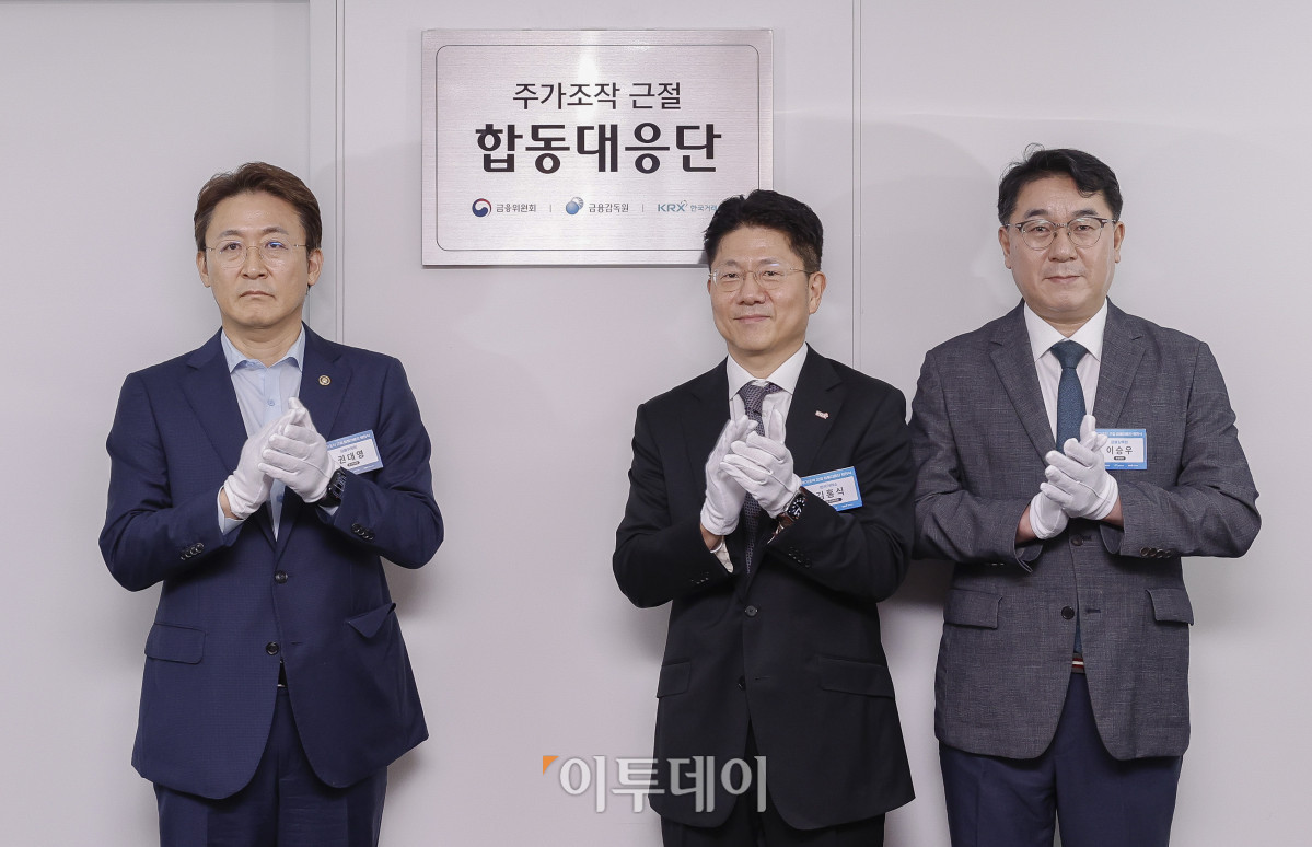 ▲권대영(왼쪽부터) 금융위원회 부위원장과 김홍식 한국거래소 시장감시위원장, 이승우 금융감독원 부원장보 겸 합동대응단장이 30일 서울 영등포구 한국거래소에서 열린 주가조작 근절 합동대응단 현판식에서 현판 제막 후 박수를 치고 있다. 조현호 기자 hyunho@