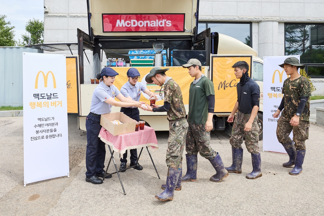 ▲가평 지역 수해 복구에 참여한 군 장병들이 맥카페 음료트럭 앞에서 버거와 음료를 수령하고 있다 (사진제공=한국맥도날드)