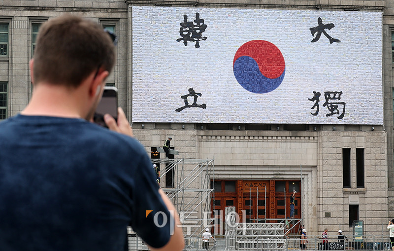 ▲3일 서울 중구 서울도서관 외벽 대형 글판인 꿈새김판이 '광복 80주년, 서울의 기억'을 주제로 새롭게 단장한 가운데 한 관광객이 글판을 카메라에 담고 있다. 꿈새김판은 안중근 의사의 혈서 태극기를 바탕으로 서울 독립유공자 사진 150여점, 서울기록원이 보유하고 있는 광복 당시의 사진과 이후 서울 주요 장소 사진 등 총 4000여 장의 사진을 활용해 포토모자이크로 만들었다. 고이란 기자 photoeran@