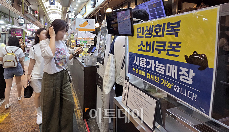 ▲서울 마포구 망원시장에 민생회복 소비쿠폰 안내문이 붙어있는 가운데 점포 마다 시민들이 북적이고 있다. 고이란 기자 photoeran@