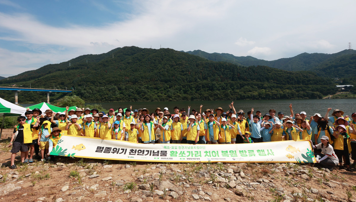 ▲에쓰오일(S-OIL) 임직원 가족, 대학생 천연기념물지킴이단 등 황쏘가리 치어 방류 봉사활동 참가자들이 기념촬영을 하고 있다. (사진= 에쓰오일)