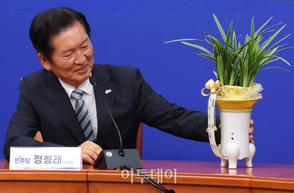 ▲정청래 더불어민주당 대표가 10일 서울 여의도 국회에서 우상호 대통령실 정무수석이 전달한 이재명 대통령의 축하난을 살펴보고 있다. 고이란 기자 photoeran@