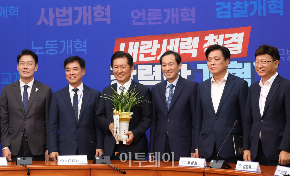 ▲우상호(오른쪽 세번째) 대통령실 정무수석이 10일 서울 여의도 국회에서 정청래(오른쪽 네번째) 더불어민주당 대표를 예방해 이재명 대통령의 축하난을 전달하고 참석자들과 기념촬영을 하고 있다. 고이란 기자 photoeran@