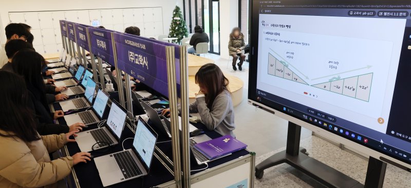 ▲올해 3월 도입을 앞둔 'AI 디지털교과서 상설 전시회'가 열린 18일 부산 북구 SW·AI교육거점센터에서 지역 교사들이 AI 디지털교과서를 살펴보고 있다. (뉴시스)