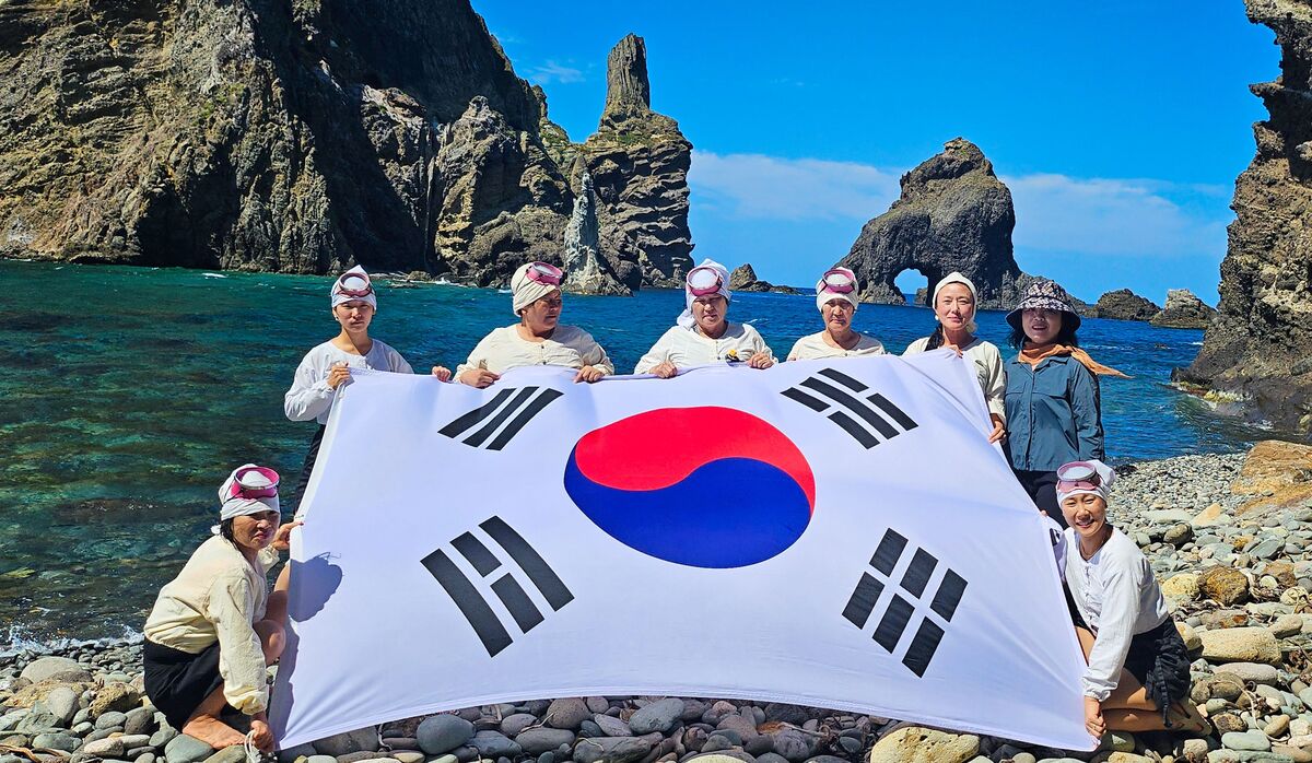 ▲제주 해녀들이 2024년 9월 5일 50년만에 경북 울릉군 독도를 찾아 물질시연을 한 뒤 태극기를 펼쳐 보이고 있다. (사진제공=제주도)