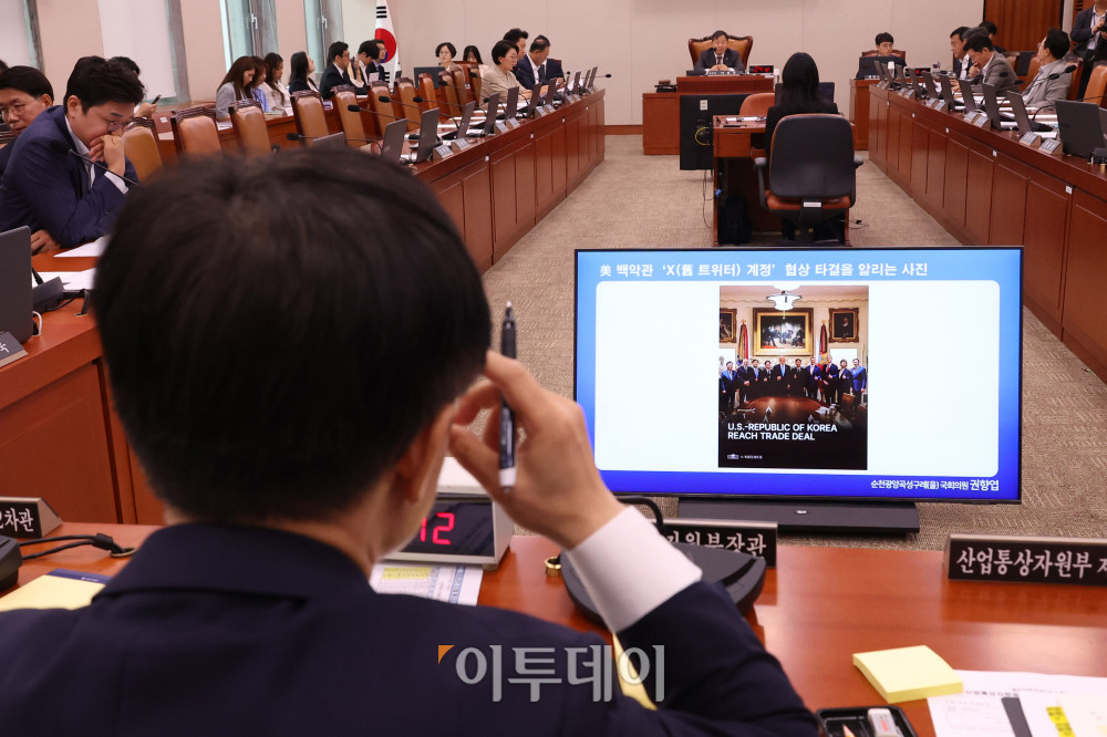 ▲김정관 산업통상자원부 장관이 6일 서울 여의도 국회에서 열린 산업통상자원중소벤처기업위원회 전체회의에서 한미 관세 협상 타결 후 한국 정부 협상단과 도널드 트럼프 미국 대통령이 백악관에서 찍은 사진을 보며 당시 분위기를 전하고 있다. 고이란 기자 photoeran@