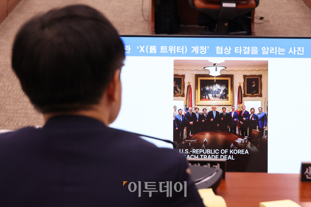 ▲김정관 산업통상자원부 장관이 6일 서울 여의도 국회에서 열린 산업통상자원중소벤처기업위원회 전체회의에서 한미 관세 협상 타결 후 한국 정부 협상단과 도널드 트럼프 미국 대통령이 백악관에서 찍은 사진을 보며 당시 분위기를 전하고 있다. 고이란 기자 photoeran@