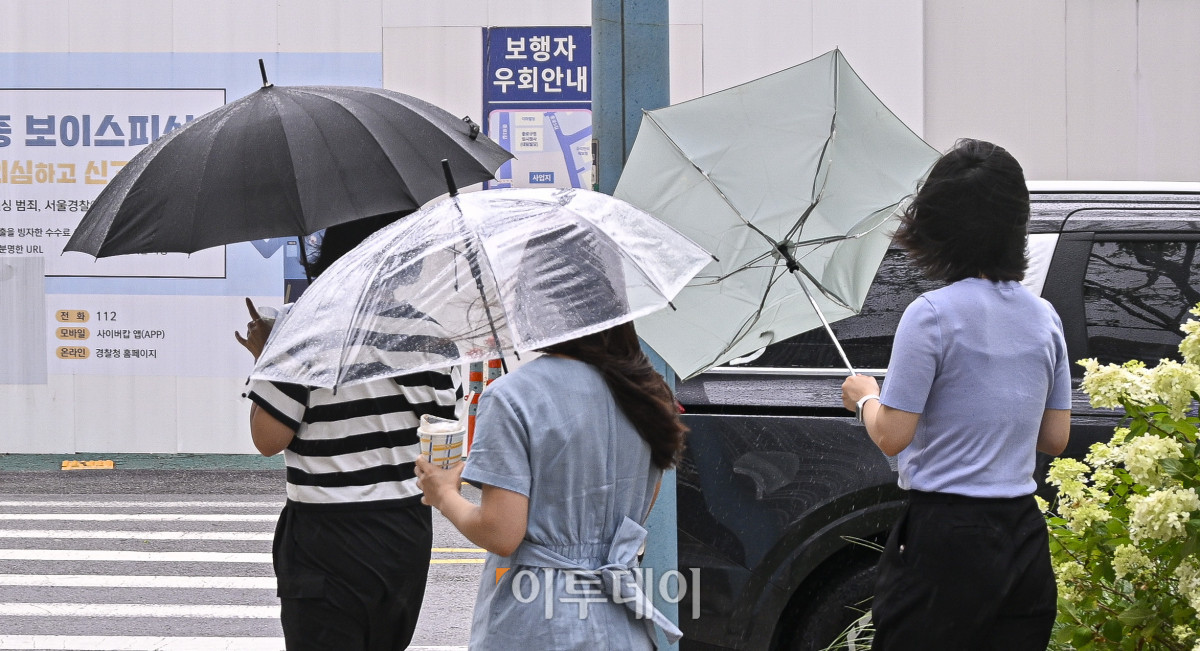 ▲6일 서울 종로구 광화문역 일대에서 우산을 쓴 시민이 돌풍으로 인해 뒤집힌 우산을 부여잡고 있다. (조현호 기자 hyunho@)