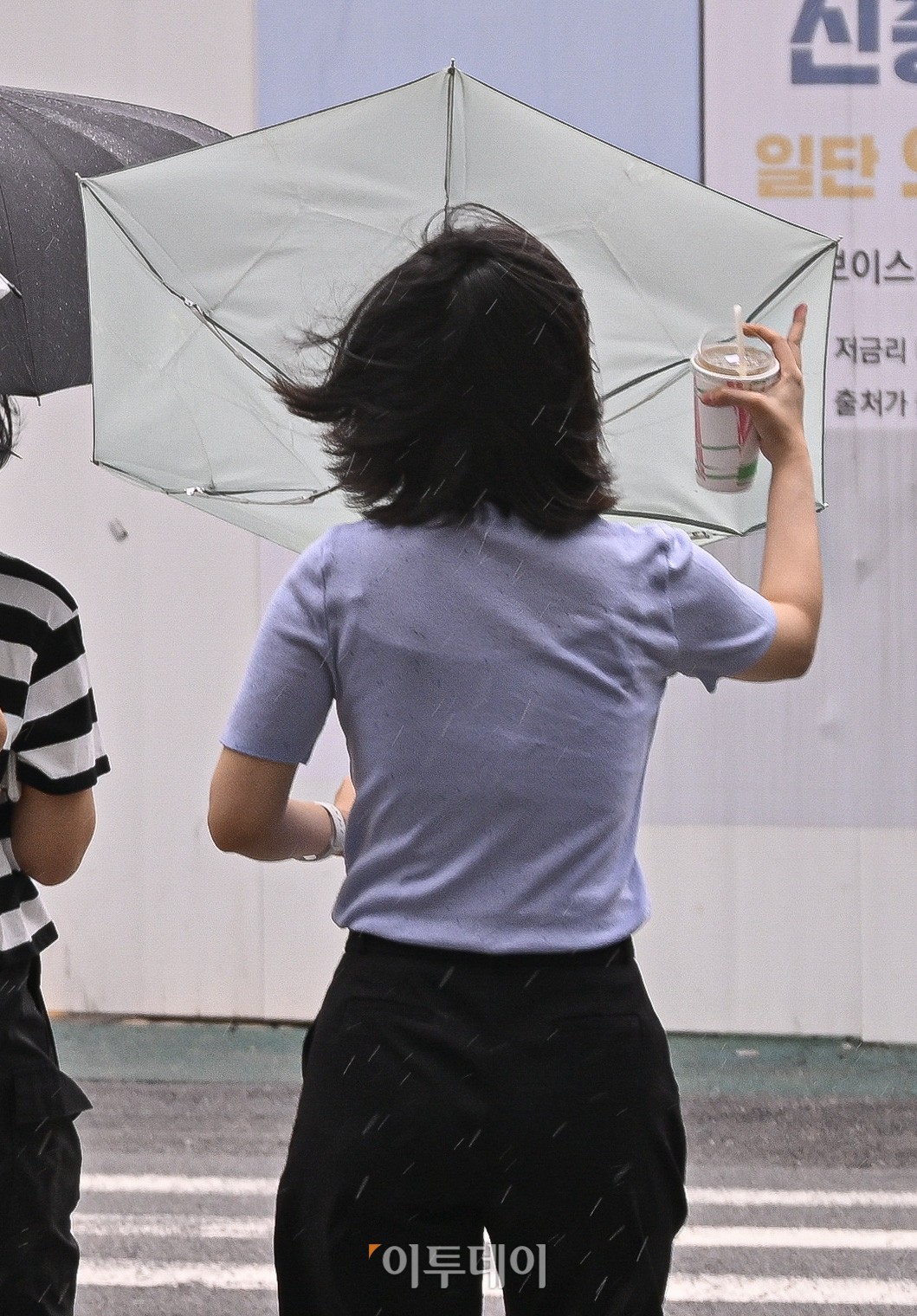 ▲전국 대부분 지역에 돌풍과 함께 천둥·번개를 동반한 많은 비가 내린 6일 서울 종로구 광화문역 일대에서 우산을 쓴 시민이 돌풍으로 인해 뒤집힌 우산을 부여잡고 있다. 기상청에 따르면 새벽에 중부지방과 경북 북부에 비가 시작돼 오전부터 그 밖의 남부지방과 제주도로 확대될 것으로 예보했다. 조현호 기자 hyunho@