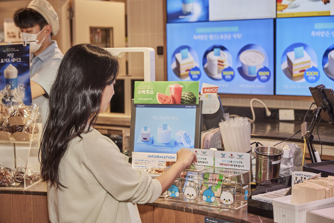 ▲ ‘파리바게뜨 인천공항 에어랩’에 설치된 모금함에 고객이 기부하고 있다.  (사진제공=SPC그룹)