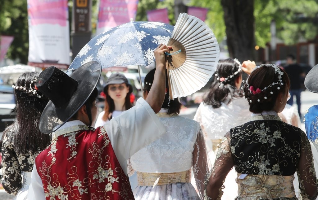 ▲전주 한옥마을 방문한 관광객들이 무더위에 부채로 햇볕을 가리고 있다. (사진제공=연합뉴스)