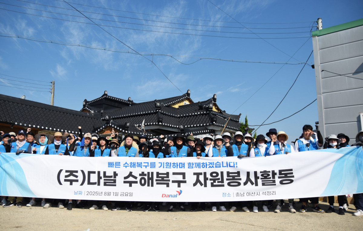 ▲다날 임직원들이 아산시 수혜복구 자원봉사에 참여해 기념사진을 찍고 있다.  (사진제공=다날)