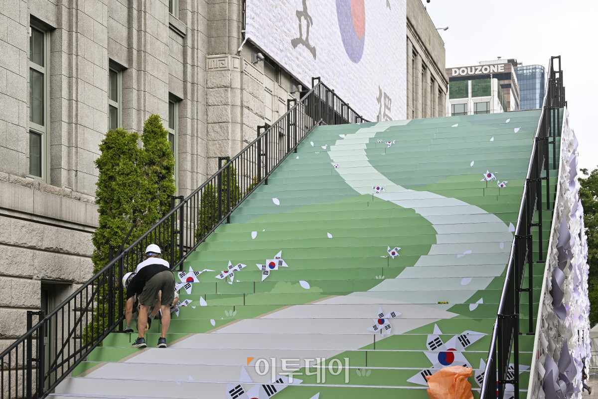 ▲제80주년 8·15 광복절을 앞둔 8일 서울 중구 서울도서관 정문 앞에 태극기 언덕이 설치되고 있다. 가로 45m·폭 5m·높이 6m 규모의 태극기 언덕은 우리 민족이 광복을 염원하며 흔들었던 태극기를 형상화한 세 가지 크기, 300개의 바람개비로 꾸며 광복의 자부심과 기쁨을 형상화한 작품이다. 시민들은 언덕에 직접 올라 꿈새김판에 걸려 있는 안중근 열사의 '단지동맹 혈서 태극기' 가까이에서 기념사진을 찍고, 서울광장에 펼쳐지는 다양한 전시와 행사도 조망할 수 있다. 조현호 기자 hyunho@
