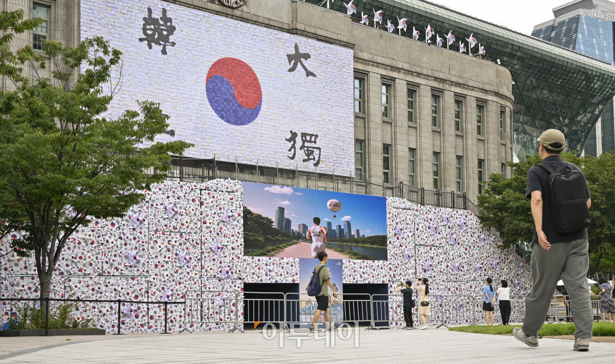 ▲제80주년 8·15 광복절을 앞둔 8일 서울 중구 서울도서관 정문 앞에 태극기 언덕이 설치되고 있다. 가로 45m·폭 5m·높이 6m 규모의 태극기 언덕은 우리 민족이 광복을 염원하며 흔들었던 태극기를 형상화한 세 가지 크기, 300개의 바람개비로 꾸며 광복의 자부심과 기쁨을 형상화한 작품이다. 시민들은 언덕에 직접 올라 꿈새김판에 걸려 있는 안중근 열사의 '단지동맹 혈서 태극기' 가까이에서 기념사진을 찍고, 서울광장에 펼쳐지는 다양한 전시와 행사도 조망할 수 있다. 조현호 기자 hyunho@