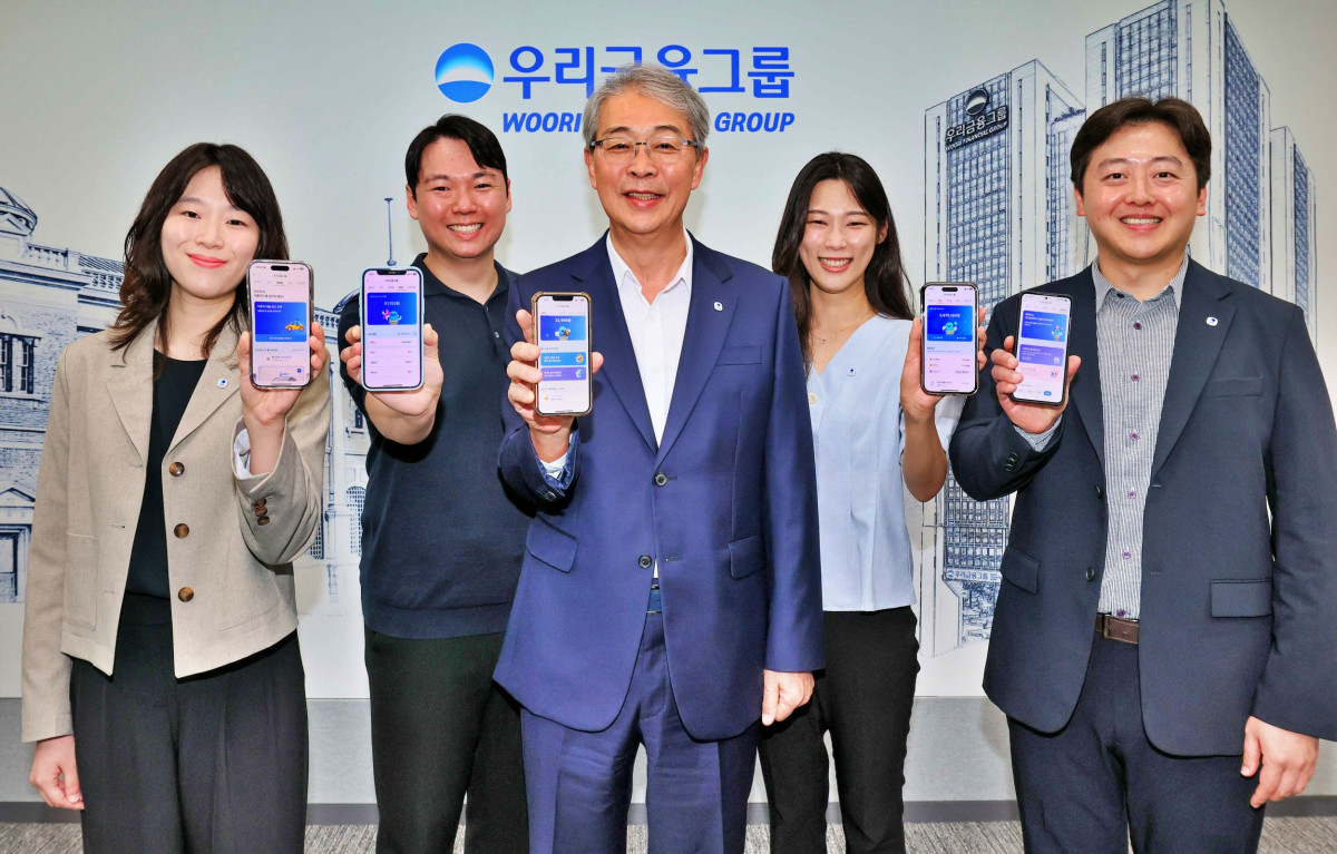 ▲임종룡 우리금융 회장(가운데)이 유니버설뱅킹 신규 가입자 100만명 돌파를 기념해 사진을 찍고 있다. (사진제공=우리금융)