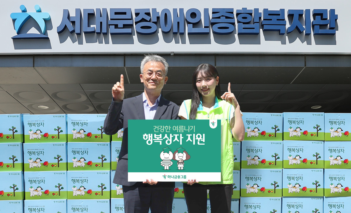 ▲하나금융그룹은 연일 이어지는 폭염으로 어려움을 겪는 장애인 및 장애인 가족을 위해 폭염 대비 물품이 담긴 『건강한 여름나기 행복상자』 1,111개를 전달했다.이날 행사에 참석한 하나금융그룹 직원이 송용성 서대문장애인종합복지관장(사진 왼쪽)에게 행복상자를 전달하며 기념촬영을 하고 있다. (사진제공=하나금융)