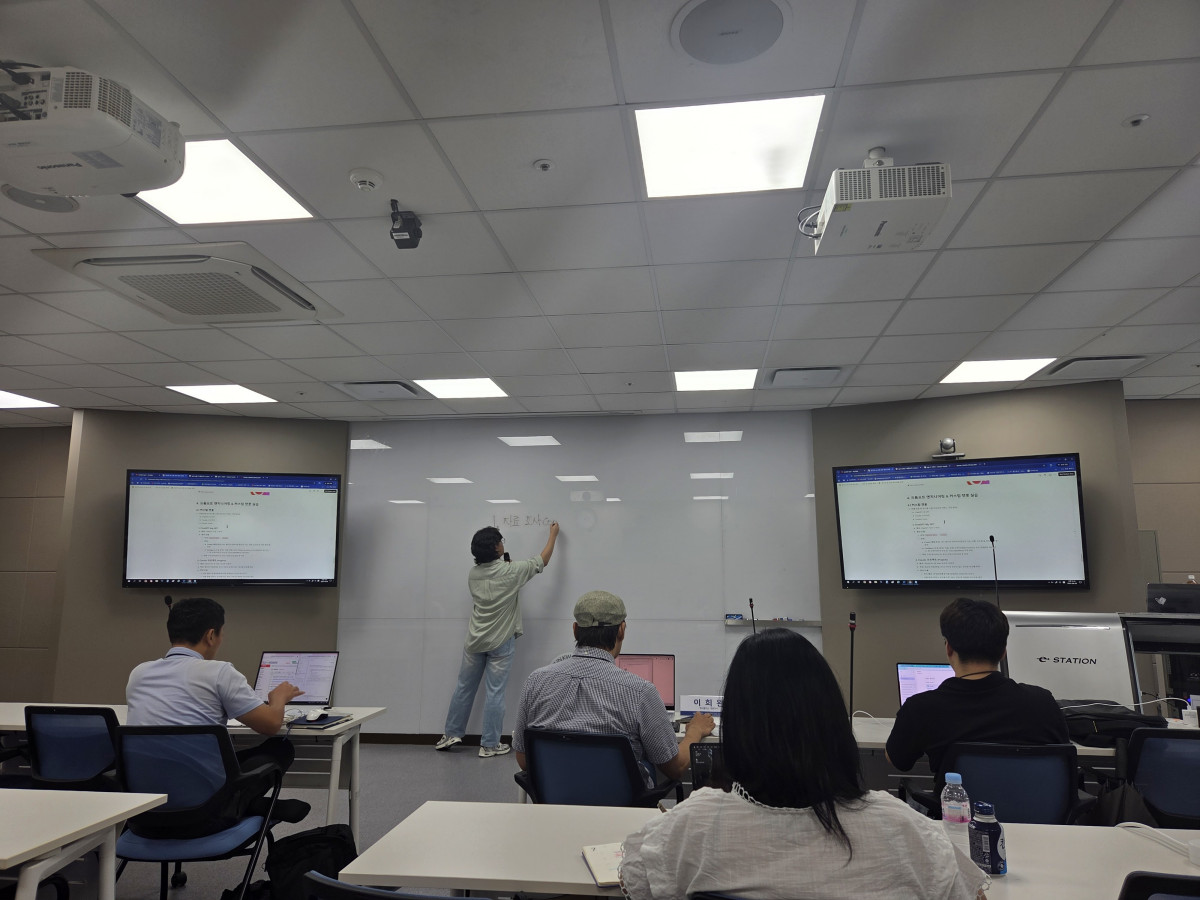 ▲강사가 화이트보드에 프롬프트 작성 원칙을 설명하며 챗봇 제작 과정을 안내하는 모습. (김재학 기자)