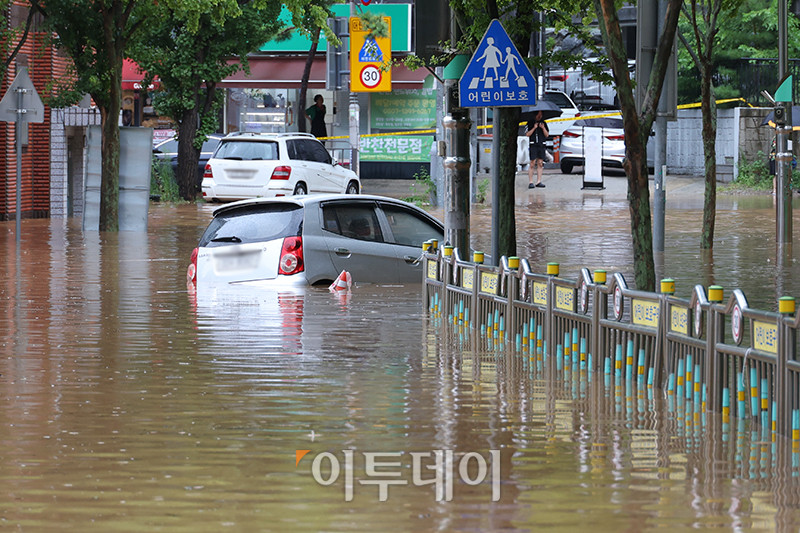 ▲수도권에 호우 경보가 내려진 13일 경기 김포 고촌초등학교 일대 도로가 침수 피해로 통제되고 있다. 기상청은 14일 오전까지 수도권을 중심으로 시간당 50~70mm의 폭우가 쏟아질 것으로 예측하며 산사태, 제방 붕괴, 침수 등 피해 예방에 각별한 주의를 당부했다. 고이란 기자 photoeran@