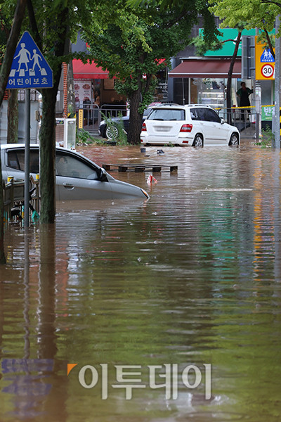 ▲수도권에 호우 경보가 내려진 13일 경기 김포 고촌초등학교 일대 도로가 침수 피해로 통제되고 있다. 기상청은 14일 오전까지 수도권을 중심으로 시간당 50~70mm의 폭우가 쏟아질 것으로 예측하며 산사태, 제방 붕괴, 침수 등 피해 예방에 각별한 주의를 당부했다. 고이란 기자 photoeran@