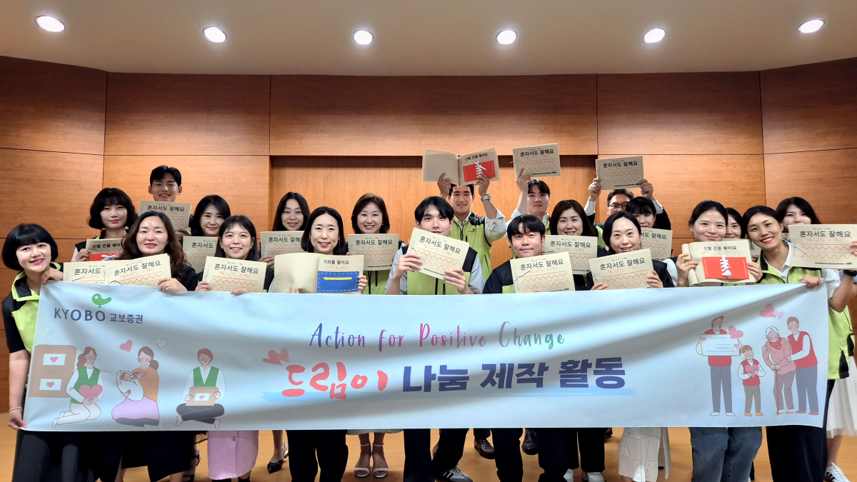 ▲교보직원 임직원들이 12일 점자촉각책 제작 봉사활동에서 기념촬영을 하고 있다. (사진=교보증권)