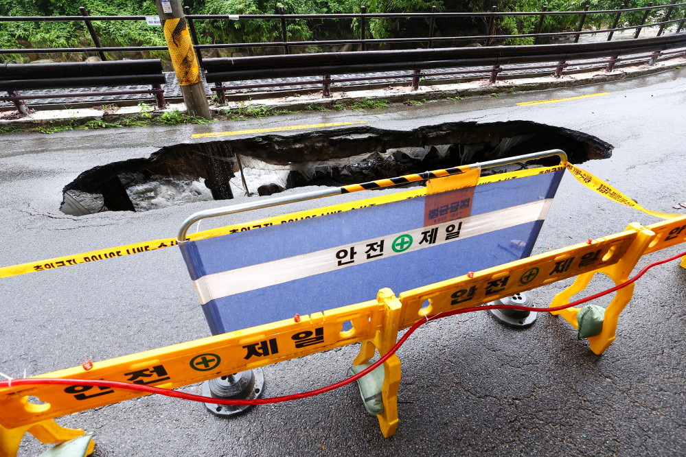▲서울 곳곳에 호우주의보가 내린 13일 집중호우로 인한 땅 꺼짐 현상이 발생한 서울 강북구 도선사 진입로에 시민들의 접근을 막는 펜스가 설치돼 있다.  (연합뉴스)