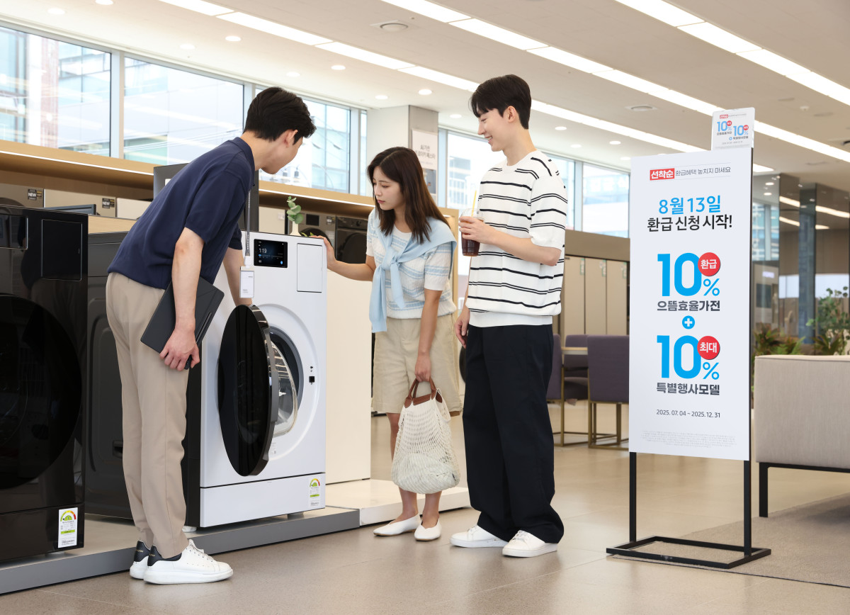 ▲삼성전자 모델이 에너지 소비효율 1등급의 '세탁건조기' 제품의 설명을 듣고 있다. (자료제공=삼성전자)